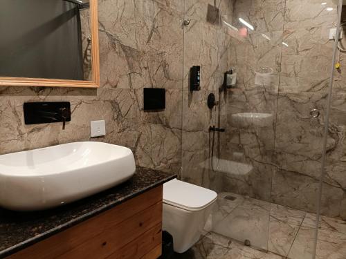 Un baño con lavabo, inodoro y ducha. en Heryk Hillview Hotel, en Dharamshala