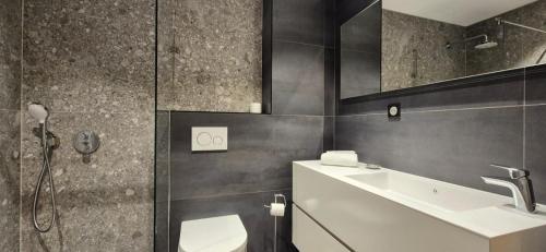 a bathroom with a sink and a toilet and a shower at Les Flambeaux - Apartment with Panoramic View - Alp'in C in Châtel
