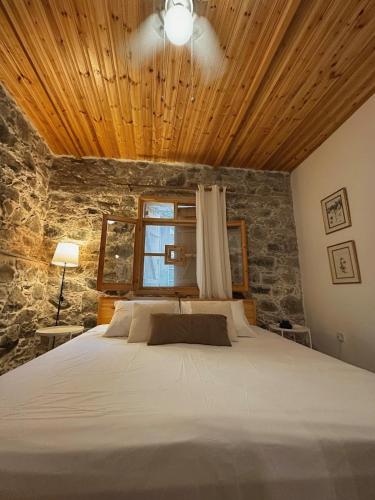 a bedroom with a large bed with a wooden ceiling at Eria Moutoullas House in Moutoullas