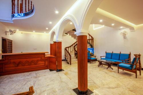a living room with blue chairs and a table at Villa Elixir Fort Kochi in Cochin