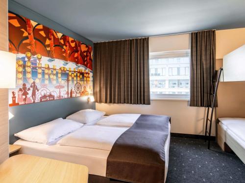 a bedroom with a bed and a painting on the wall at B&B Hotel München City-West in Munich