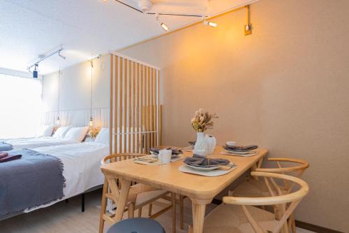 a bedroom with a table with two chairs and a bed at Joyful JUJO Stay 1minute walk from JR Jujo Station Shibuya 15min Shinjuku 11min Ikebukuro 6min Max 6guests 33square meters Simmons bed in Tokyo