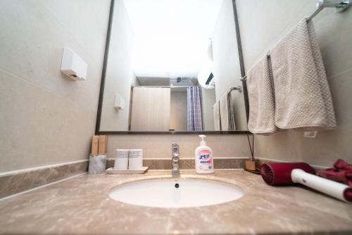 a bathroom sink with a large mirror above it at Xiao Meow B&B in Qingdao