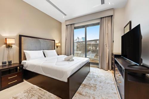 a bedroom with a bed and a flat screen tv at Chic Studio Near Burj Khalifa in Dubai