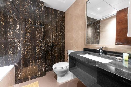 Un baño con inodoro, lavabo y espejo. en Chic Studio Near Burj Khalifa, en Dubái