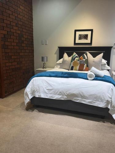 a bedroom with a large bed with a blue blanket at Rivonia Garden Suites in Johannesburg