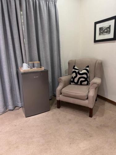 a chair with a pillow sitting next to a window at Rivonia Garden Suites in Johannesburg