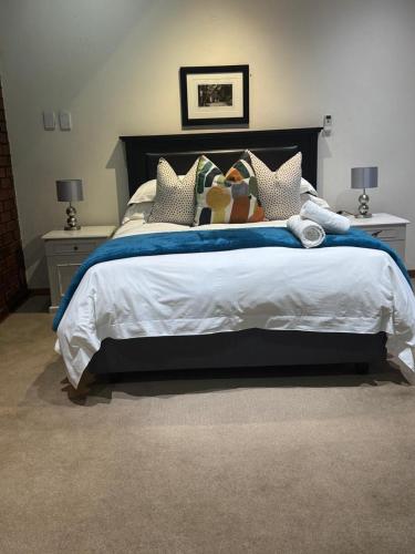 a bedroom with a large bed with many pillows at Rivonia Garden Suites in Johannesburg