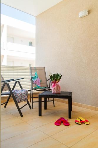 a room with a table and a chair and shoes on the floor at La Steila del Sud in Polignano a Mare