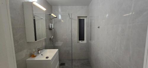 a white bathroom with a sink and a shower at Modern Full Comfort Villa in Agnesberg