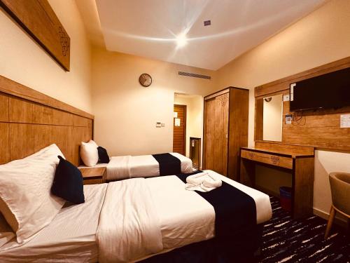 a hotel room with two beds and a television at فندق درة النمارق المتميزة in An Naqāʼ