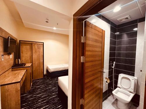 a small bathroom with a toilet and a sink at فندق درة النمارق المتميزة in An Naqāʼ
