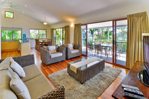 
a living room filled with furniture and a large window at Heliconia Grove 9 in Hamilton Island
