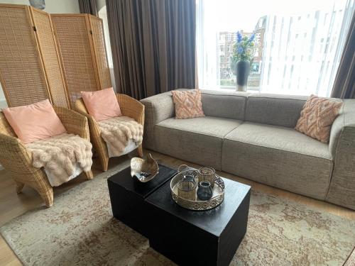 a living room with a couch and two chairs at Appartement Seepaardje in Scheveningen