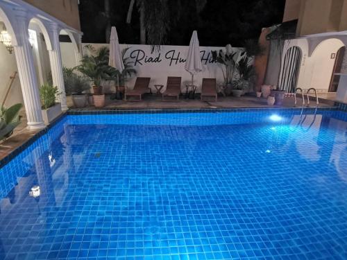 a large blue swimming pool with chairs next to it at Riad Hua Hin in Hua Hin