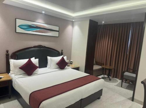 a hotel room with a large bed with red pillows at Hotel Rachna Tourist lodge in New Delhi