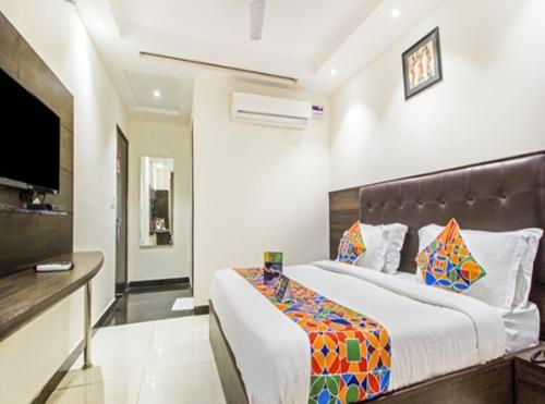 a bedroom with a large bed and a flat screen tv at Hotel Rachna Tourist lodge in New Delhi