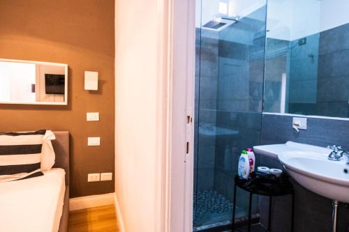 a bathroom with a sink and a glass shower at Cozy Studio Parlamento in Rome
