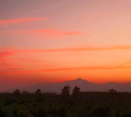 a sunset with a mountain in the background at Napahong Treehouse นาป่าฮง Andromeda & Cassiopeia in Ban Pa Ha