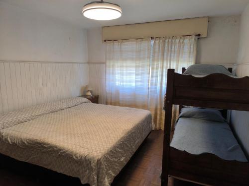 a small bedroom with two beds and a window at Casa Milu in Mina Clavero
