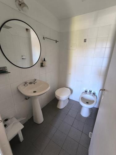 a bathroom with a sink and a toilet and a mirror at Casa Milu in Mina Clavero
