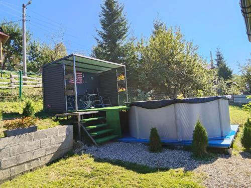 a tiny house in a yard with a shed at Садиба 'Віраж' in Vorokhta