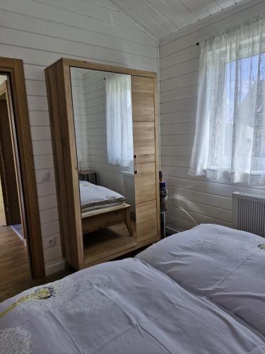 a bedroom with a bed with a mirror and a window at Ferienhaus Schindler in Johanngeorgenstadt