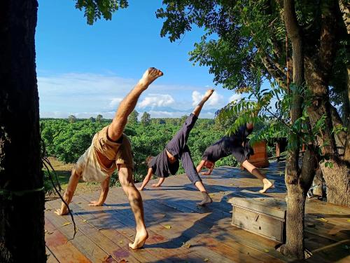 a group of men doing a handstand on a wooden deck at Napahong Treehouse นาป่าฮง Andromeda & Cassiopeia in Ban Pa Ha