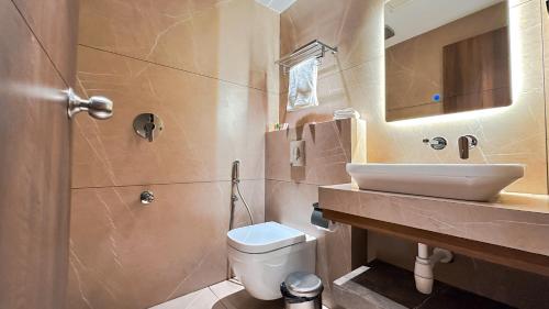 a bathroom with a white toilet and a sink at FHotels in Bengaluru