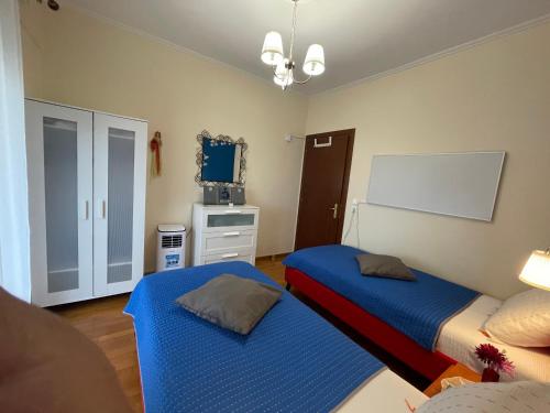 a bedroom with two beds and a tv in it at ILIADA Apartment in Litochoro