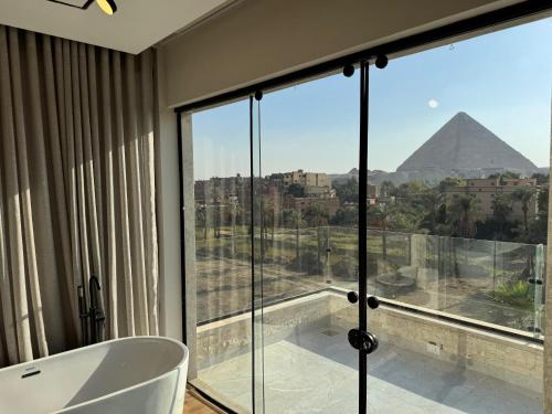 a bathroom with a tub and a view of the pyramids at Palacio Pyramids Hotel in Cairo