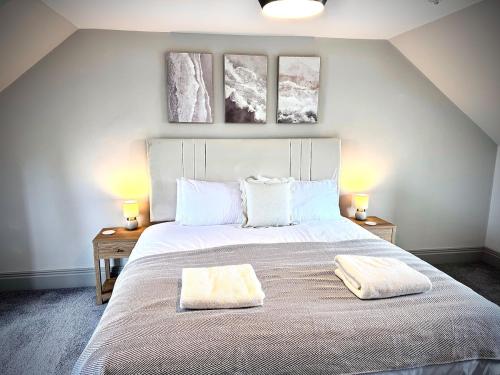 a bedroom with a large white bed with two lamps at Abhaille Chluaidh - Macaulay Letting in Helensburgh