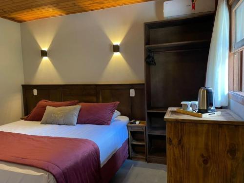 a bedroom with a bed and a television in it at Hotel Cabanas Glamour in Gramado