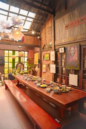 a long wooden table with bowls of food on it at Dó homestay in Sapa