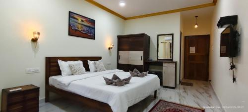 a bedroom with two beds and a television in it at Abba's Glory Land - Agonda in Agonda