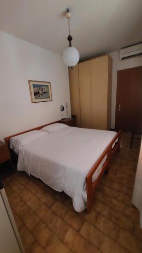 a bedroom with a large white bed in a room at Camping Alpino - Nature Village in Malcesine