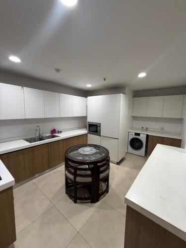 a large kitchen with a table in the middle of it at Gold Crest Apartments - 1 2 3 4 Bedroom By luxuryapartmentspk in Lahore