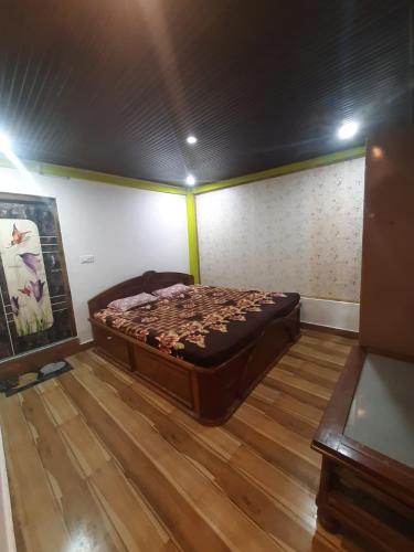 a large bed in a room with a wooden floor at Agarwal Home Stay in Jālāpahār