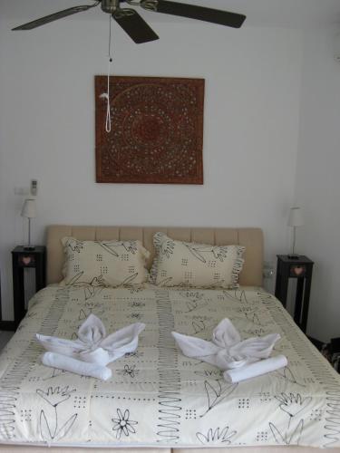 a bedroom with a bed with two towels on it at Mango Paradise, in der Nähe des Black Mountain Golf Clubs in Hua Hin