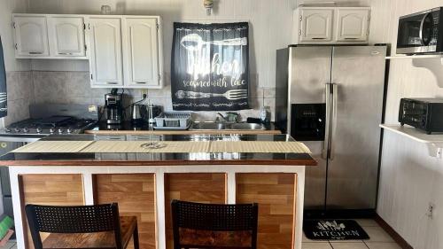 Una cocina con gabinetes blancos y un refrigerador de acero inoxidable. en Cozy 2 bedroom apartment, en Saint Johnʼs