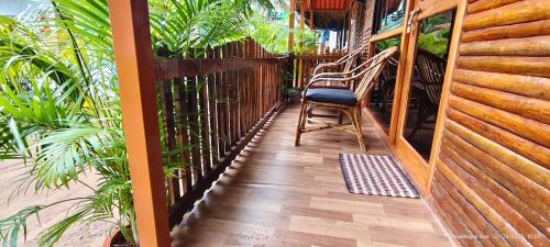 a porch with a chair and a fence at Abba's Glory Land - Agonda in Agonda
