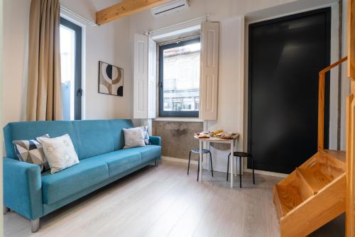 a living room with a blue couch and a table at Authentic Studio with Terrace by HostWise in Porto