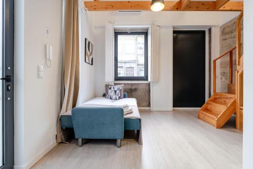 a bedroom with a bed and a chair and a window at Authentic Studio with Terrace by HostWise in Porto