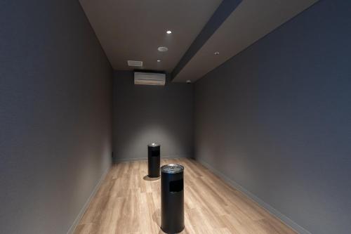 a room with two black vases on a wooden floor at KAMENOI HOTEL Oarai in Oarai