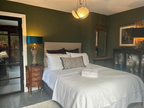 a bedroom with a white bed and a green wall at The ring fort lodge in Glenties