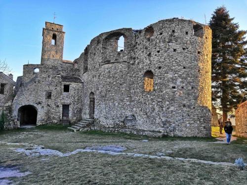 a person standing in front of an old castle at Rocca Fiorita - Bilocale con spazio esterno, parcheggio sotto casa in Baiardo