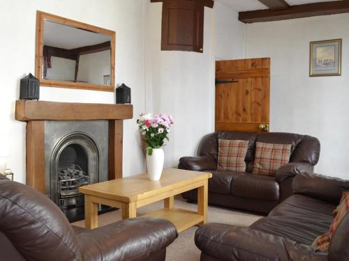 Una sala de estar con muebles de cuero y chimenea. en Belfrey House, en York
