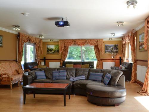 ein Wohnzimmer mit Sofa und Tisch in der Unterkunft Vijay Gardens in Glanamman