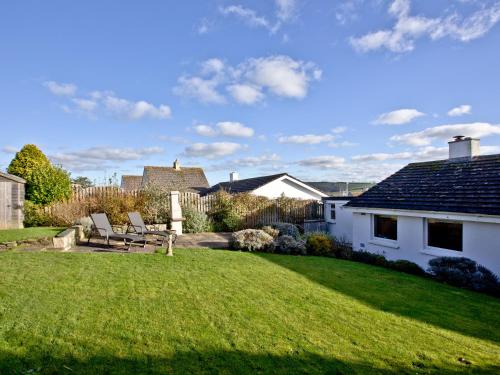 a yard with two chairs and a house at The Lodge in Fowey