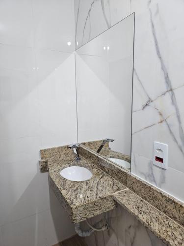 a bathroom with a sink and a mirror at Pousada e Galeria Mestre dos Magos in São Thomé das Letras